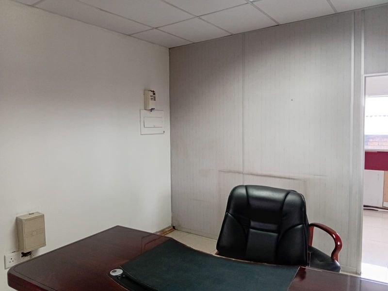 A functional office space featuring modular wall paneling, a drop ceiling, and integrated electrical points, suitable for a professional work environment.