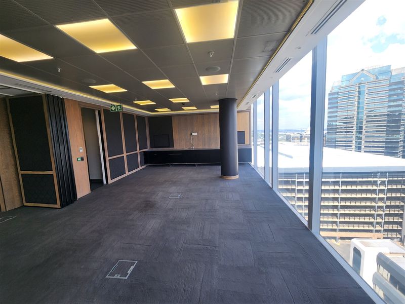 Modern, vacant office space featuring floor-to-ceiling windows with city views, suspended ceiling, built-in cabinetry, and carpeted flooring.