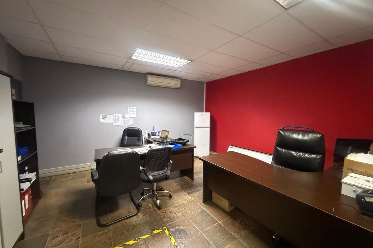 Functional office space featuring tiled flooring, recessed ceiling lighting, and a wall-mounted air conditioning unit.