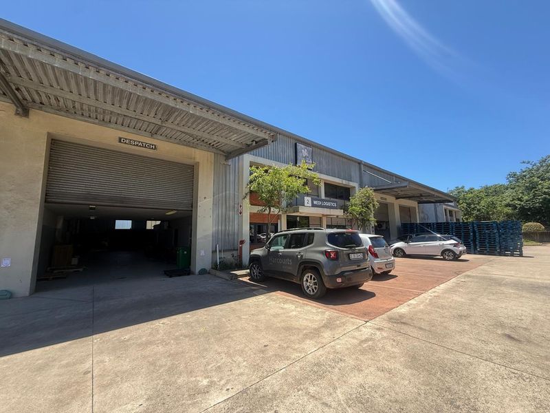 Industrial warehouse facility featuring a large despatch bay, roller shutter doors, and a paved forecourt area suitable for logistics and commercial operations.