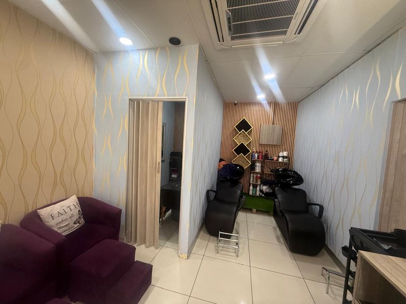 A functional salon space featuring built-in hair wash basins, recessed ceiling lighting, and integrated air conditioning unit.