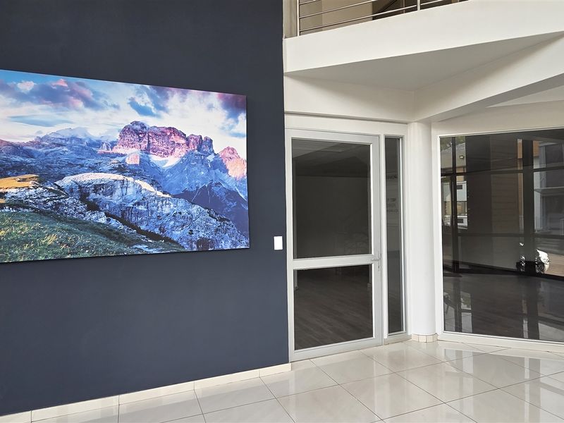 Modern office building entrance lobby featuring tiled flooring, glass doors, and a directory board for ground and first-floor tenants.