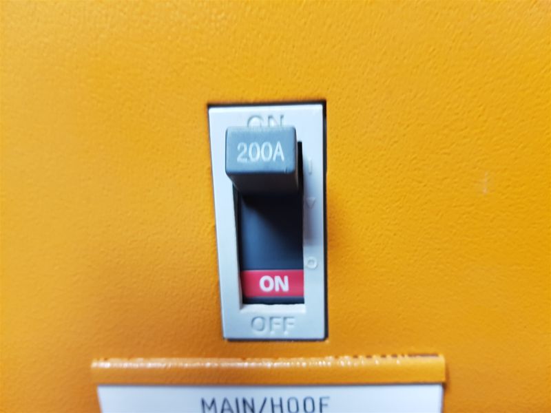 Close-up view of a 200A main electrical circuit breaker switch mounted on an industrial distribution panel.