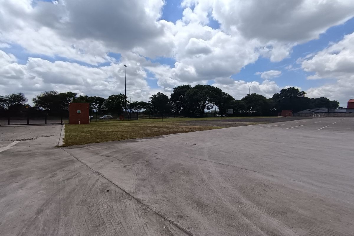Expansive concrete paved yard area suitable for industrial use, featuring perimeter fencing and open space.