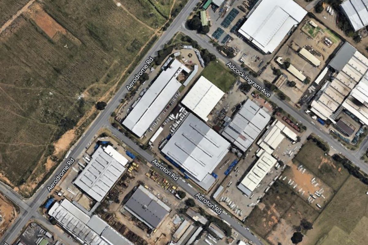 Aerial view of an industrial park featuring multiple warehouse structures, access roads, and paved yard areas.
