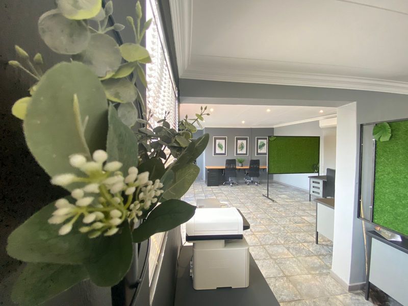 A well-maintained commercial office space featuring tiled flooring, recessed lighting, and an integrated air conditioning unit, providing a professional and functional work environment.