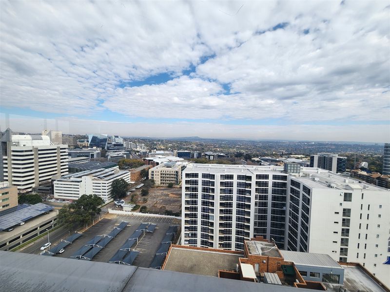 Elevated panoramic city view showcasing surrounding commercial office buildings, parking facilities, and urban infrastructure.