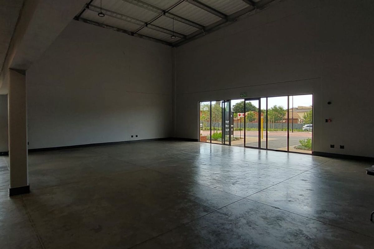 Spacious open-plan retail unit featuring polished concrete flooring, high ceilings, and large glass sliding doors providing ample natural light and street access.