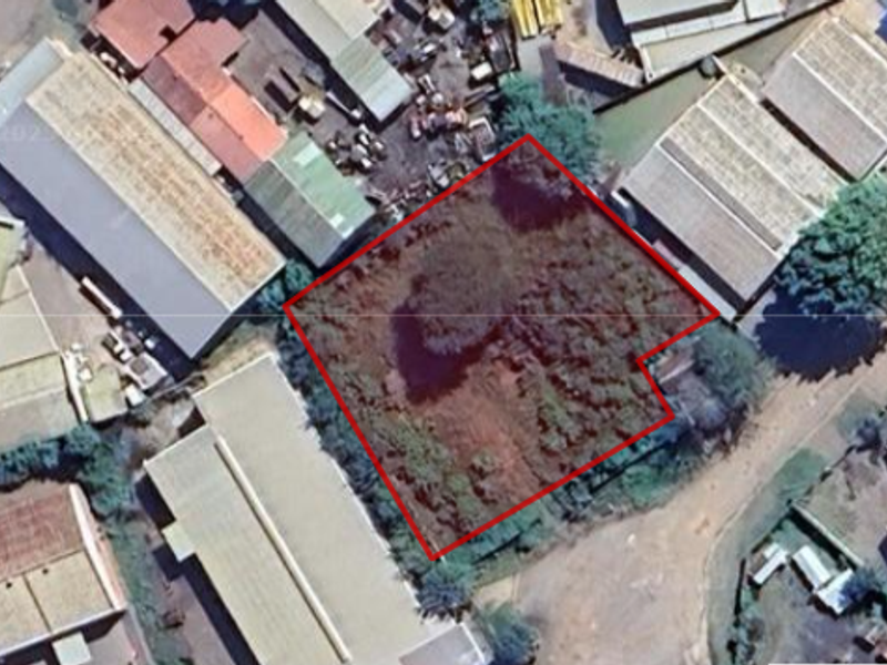 Aerial view of a vacant commercial plot situated within an established industrial area, highlighting the property boundaries and surrounding infrastructure.