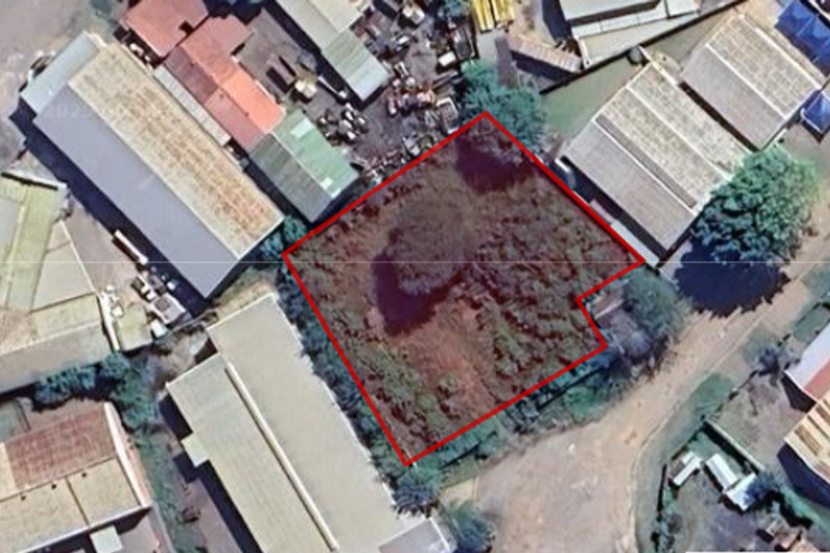 Aerial view of a vacant commercial plot situated within an established industrial area, highlighting the property boundaries and surrounding infrastructure.