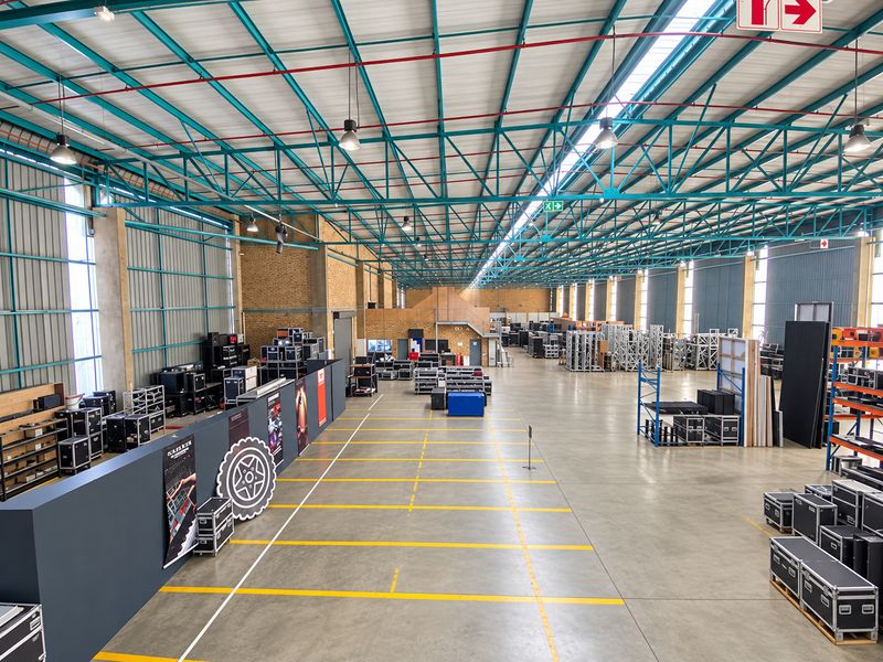 Spacious industrial warehouse featuring high ceilings with exposed steel trusses, polished concrete floors, and integrated fire safety systems.
