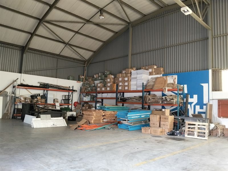 Spacious industrial warehouse unit featuring high ceilings, concrete flooring, and integrated steel racking systems suitable for storage or light manufacturing operations.