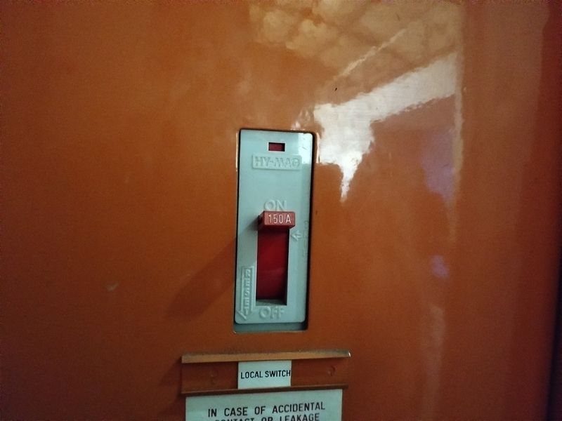 A close-up view of a 150A industrial circuit breaker switch mounted on an orange panel.