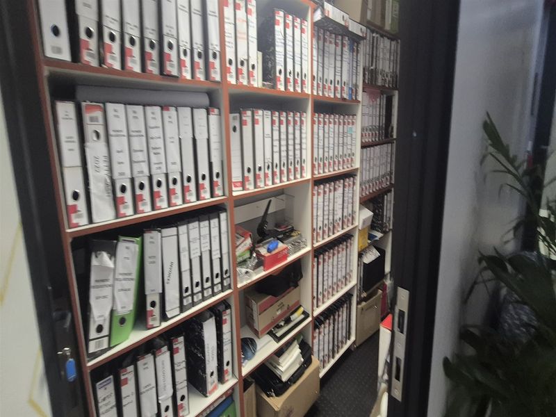 A functional office storage area featuring extensive built-in shelving units designed for organized document and file management.