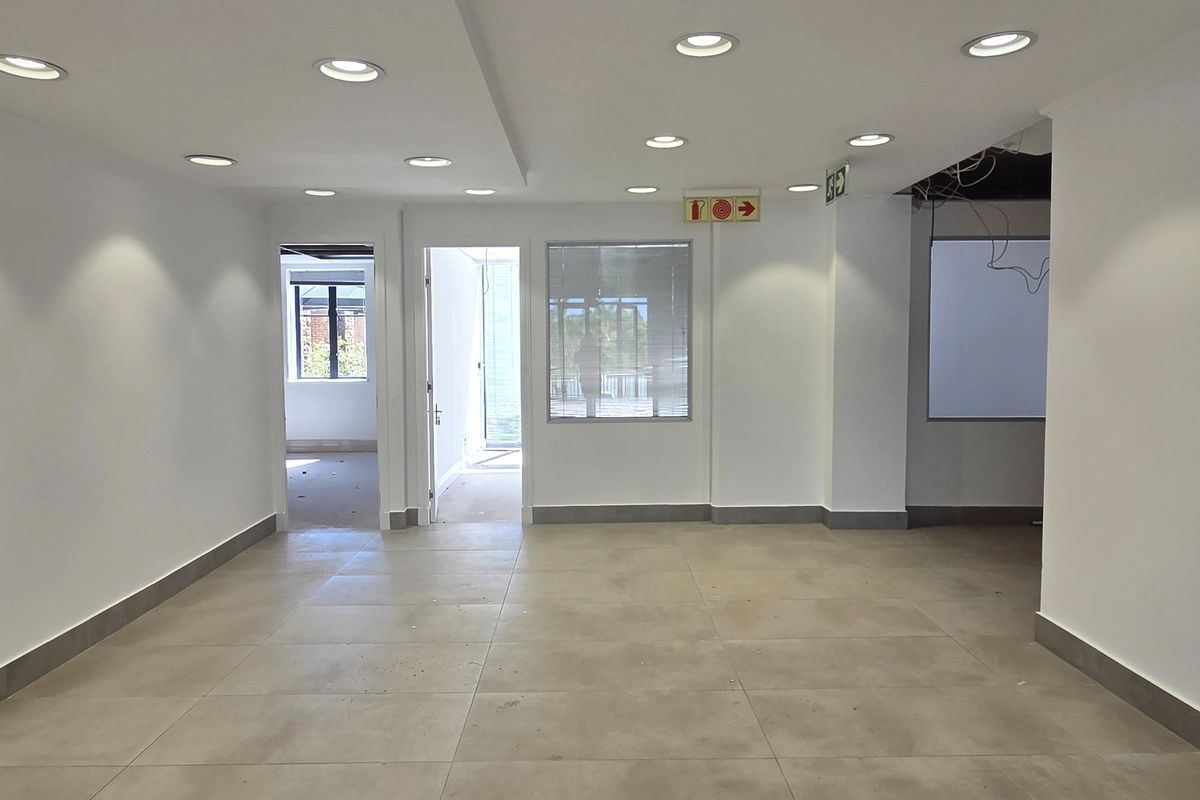An open-plan office space featuring neutral tiled flooring, recessed downlighting, and clean white walls, currently vacant and ready for custom fit-out.