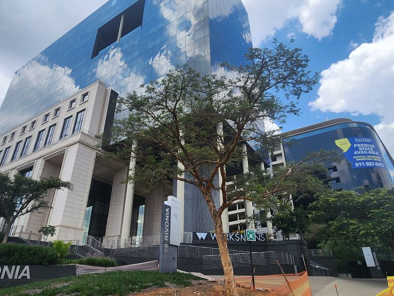 Modern commercial office building facade featuring glass curtain walls, stone cladding, and prominent signage at 96 Rivonia.