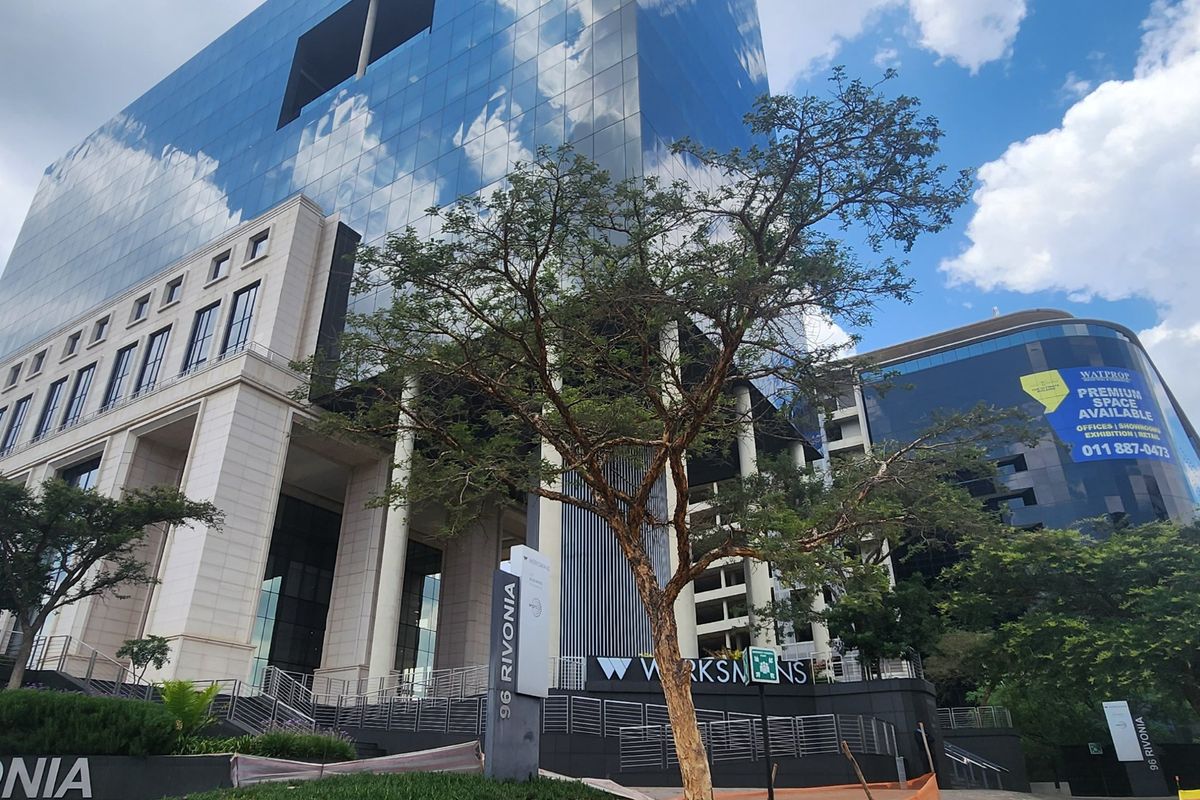 Modern commercial office building facade featuring glass curtain walls, stone cladding, and prominent signage at 96 Rivonia.