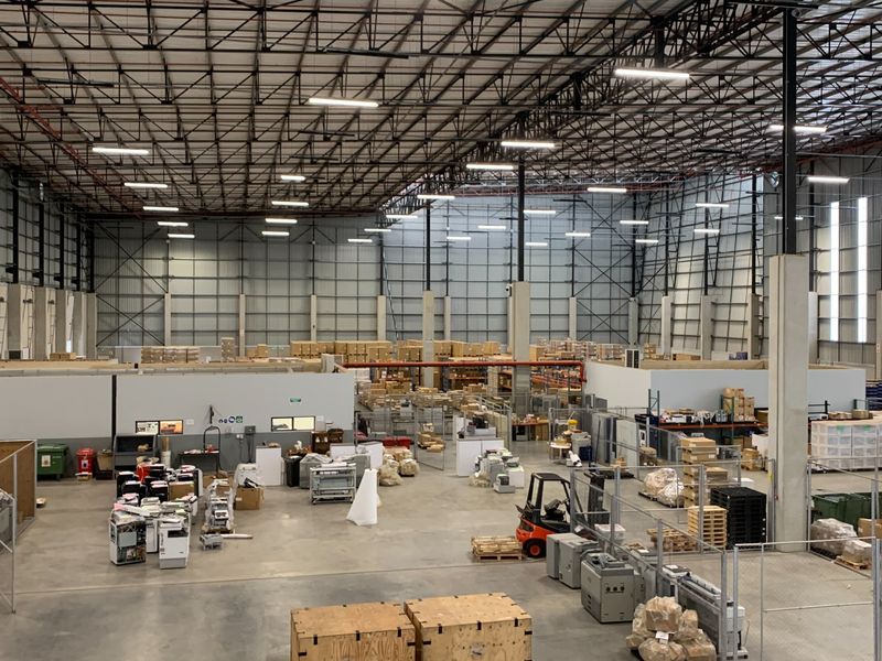 Spacious industrial warehouse featuring high ceilings with exposed steel trusses, concrete flooring, and ample open floor area for storage and logistics operations.
