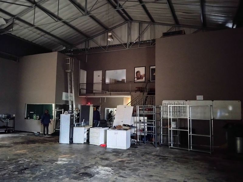 Spacious industrial utility area featuring a mezzanine level, exposed metal roof structure, and concrete flooring, suitable for warehouse or workshop operations.