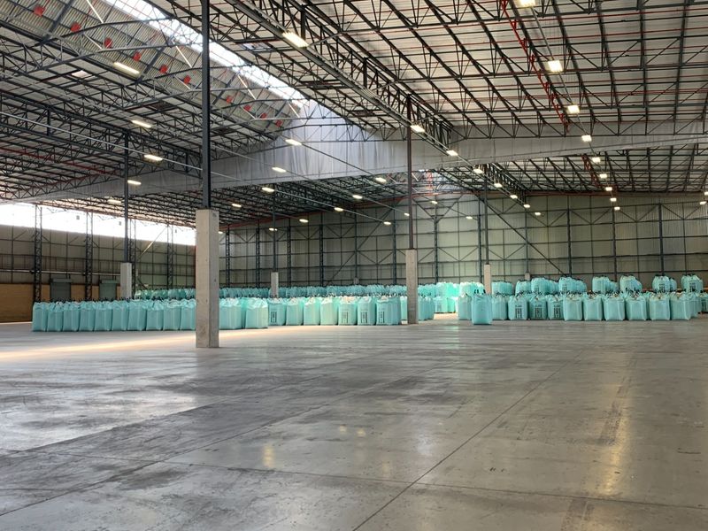 Spacious industrial warehouse featuring high ceilings with exposed steel trusses, polished concrete flooring, and integrated fire sprinkler systems.