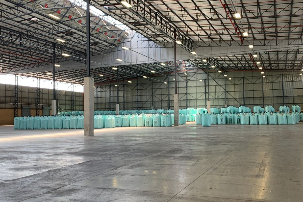 Spacious industrial warehouse featuring high ceilings with exposed steel trusses, polished concrete flooring, and integrated fire sprinkler systems.