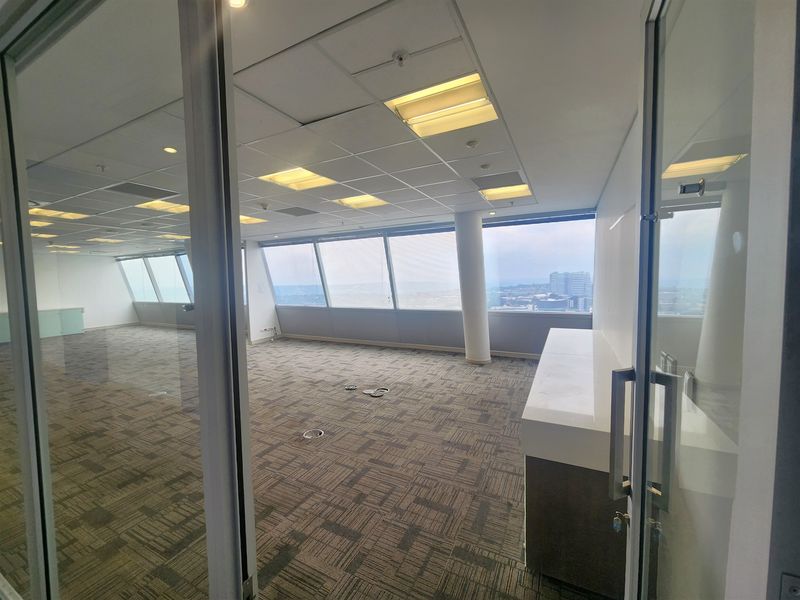Spacious open-plan office suite featuring floor-to-ceiling windows with city views, suspended ceilings, and integrated floor power access points.