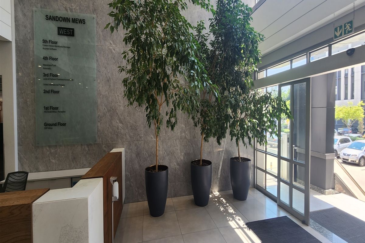 Modern office building entrance lobby featuring marble wall cladding, a professional directory board, and a reception desk with glass door access.