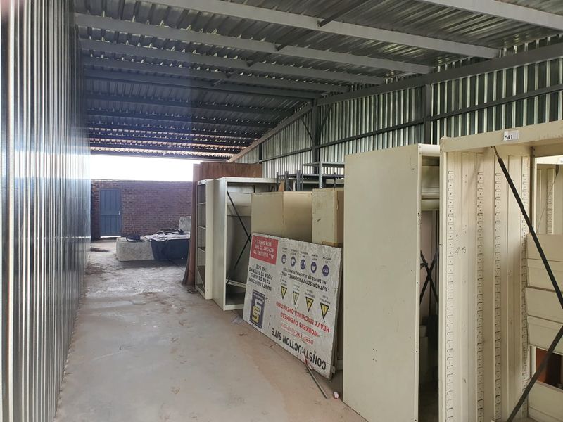 Industrial storage or utility space featuring corrugated metal walls and roofing with an open-plan layout.
