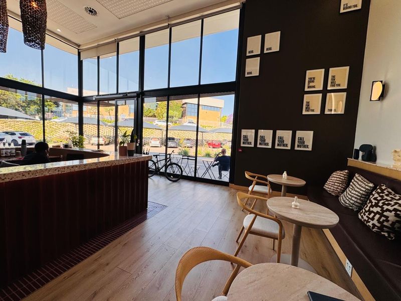 Modern office space featuring floor-to-ceiling windows, a built-in service counter, and integrated bench seating with contemporary finishes.