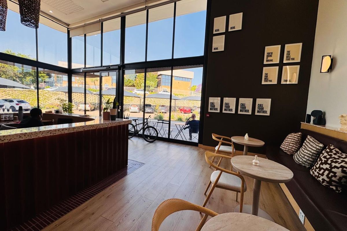 Modern office space featuring floor-to-ceiling windows, a built-in service counter, and integrated bench seating with contemporary finishes.
