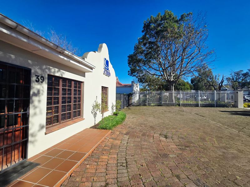 Front exterior view of the office property featuring a paved driveway, security fencing, and a tiled entrance porch.