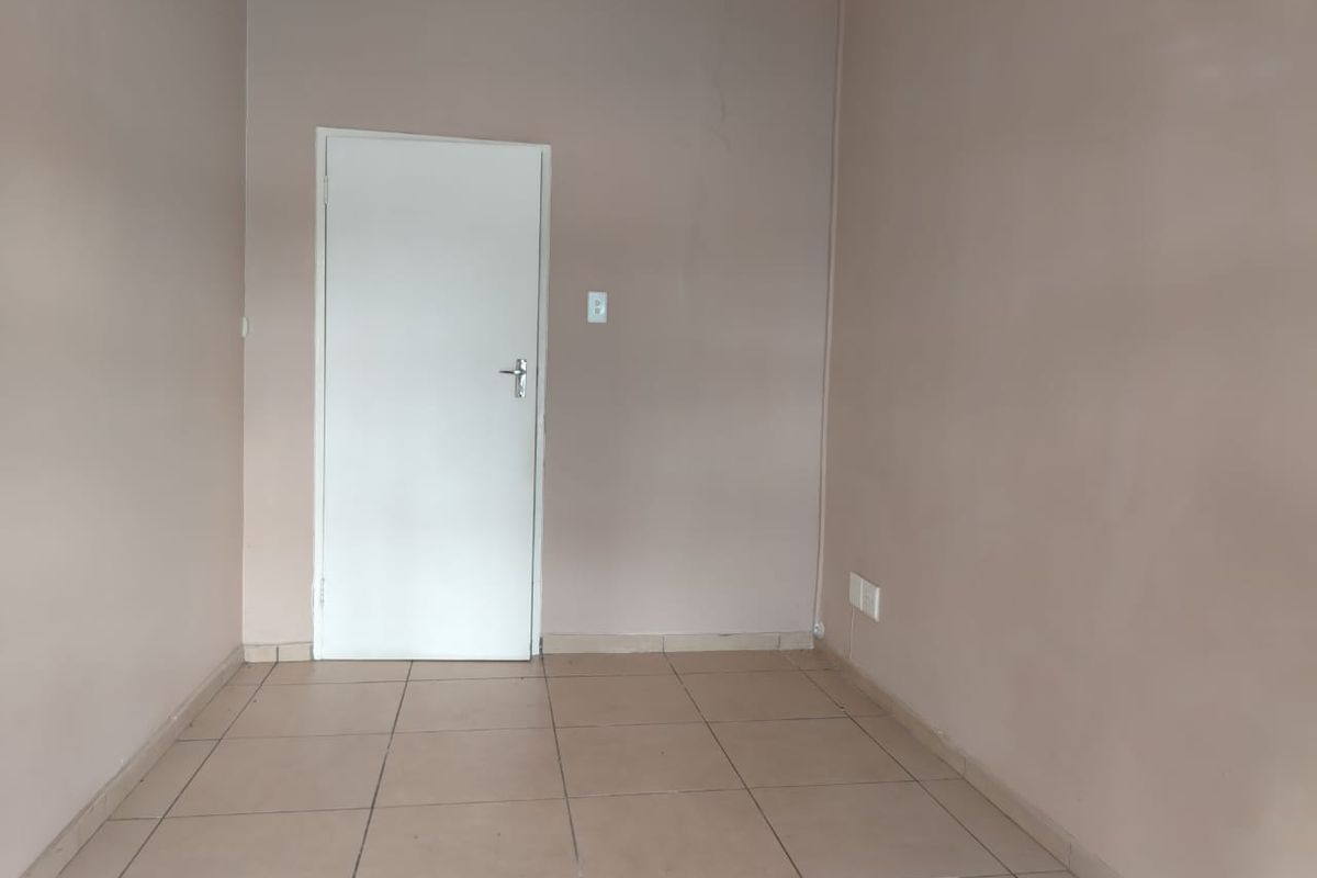 A vacant bedroom featuring neutral wall paint and tiled flooring, providing a blank canvas for office or residential use.