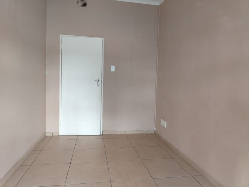 A vacant bedroom featuring neutral wall paint and tiled flooring, providing a blank canvas for office or residential use.
