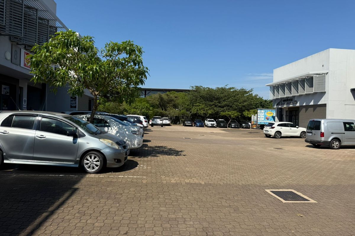 Exterior view of an industrial property featuring a paved parking lot and modern building facades with integrated sun screening.