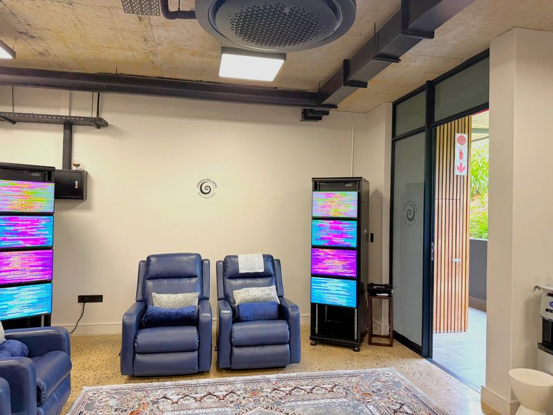 Modern office space featuring exposed concrete ceilings, terrazzo flooring, and a glass door leading to an outdoor area.