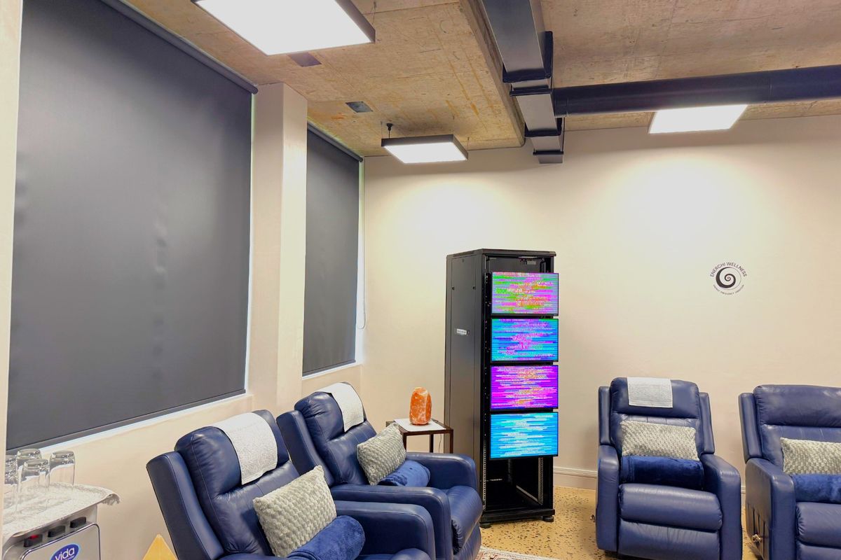 Modern office space featuring an exposed concrete ceiling with industrial ductwork, recessed LED lighting, roller blinds, and durable terrazzo flooring.