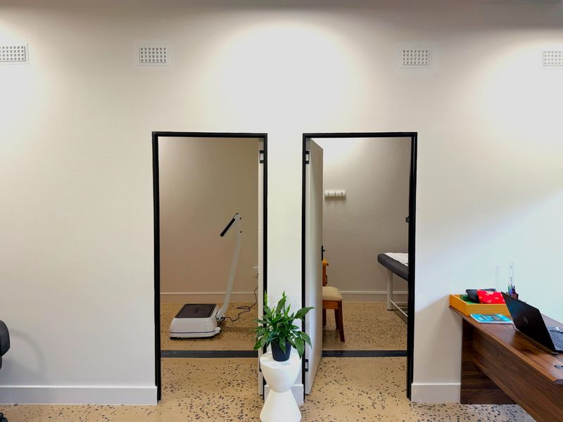 A professional office space featuring modern terrazzo flooring and dual doorways leading into separate functional rooms with clean white wall finishes.