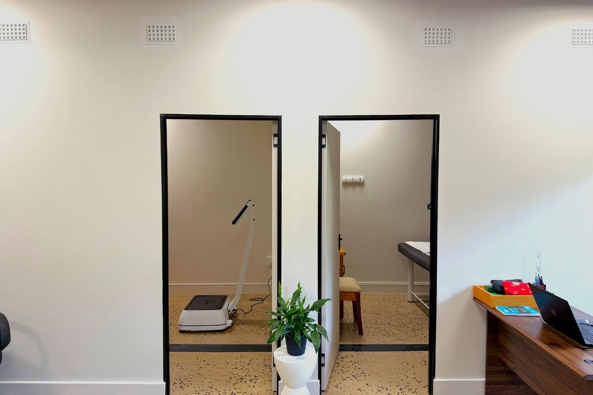 A professional office space featuring modern terrazzo flooring and dual doorways leading into separate functional rooms with clean white wall finishes.