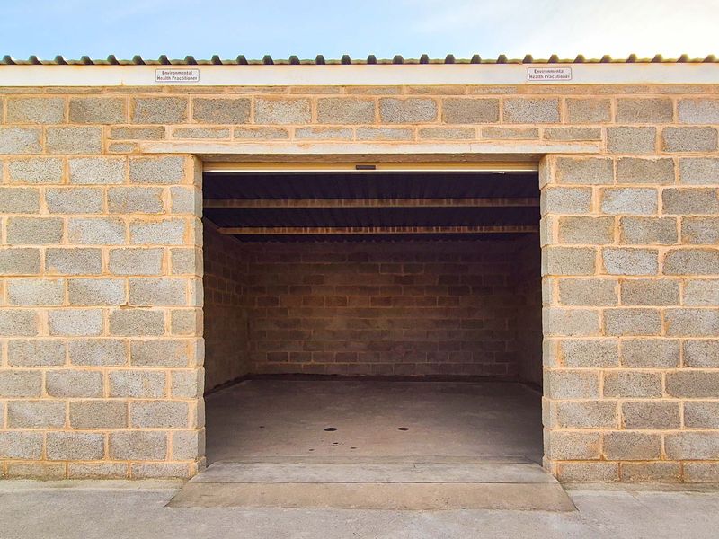 A functional industrial garage space featuring exposed concrete block walls, a corrugated metal roof, and a durable concrete floor.