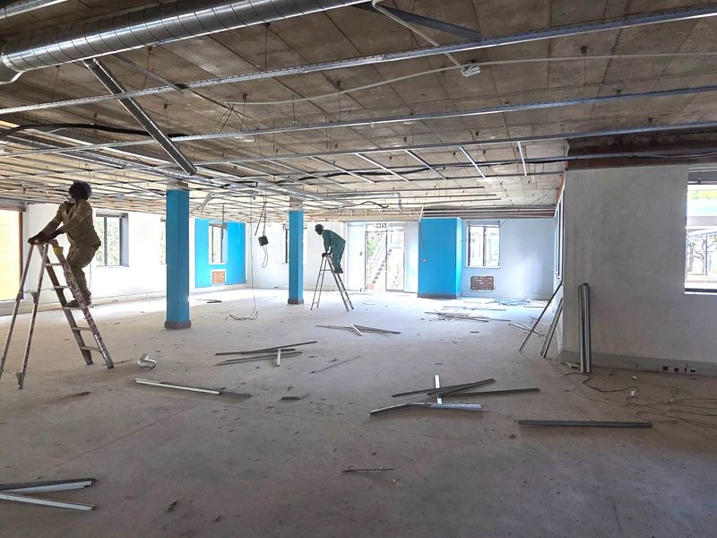 An open-plan office space currently under renovation, featuring exposed ceiling infrastructure, structural columns, and concrete flooring, offering a blank canvas for custom fit-out.