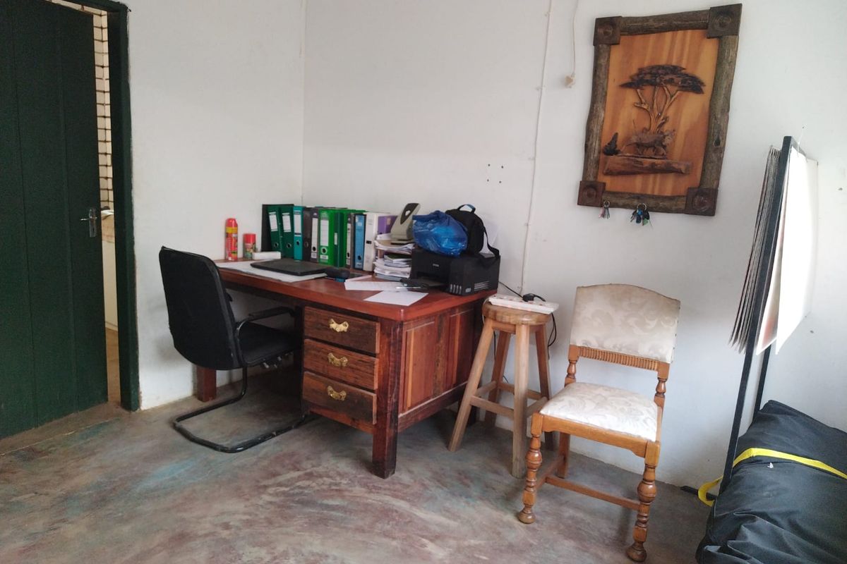 A functional office space featuring a painted concrete floor and simple interior finishes, suitable for a small workspace or administrative area.