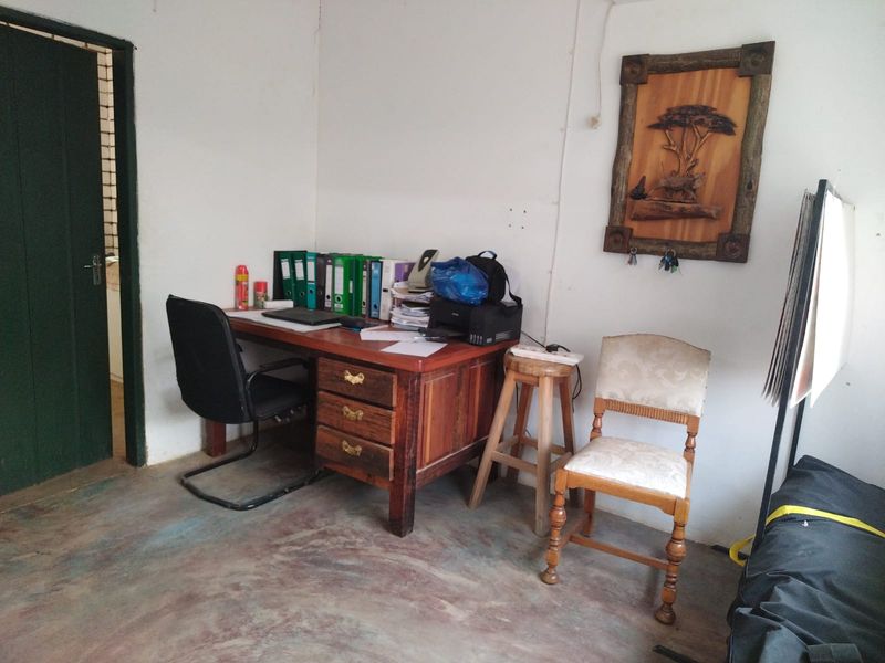 A functional office space featuring a painted concrete floor and simple interior finishes, suitable for a small workspace or administrative area.