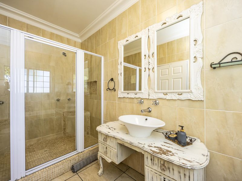 A bathroom featuring a walk-in shower with a glass enclosure, tiled walls and flooring, and a vessel sink vanity.