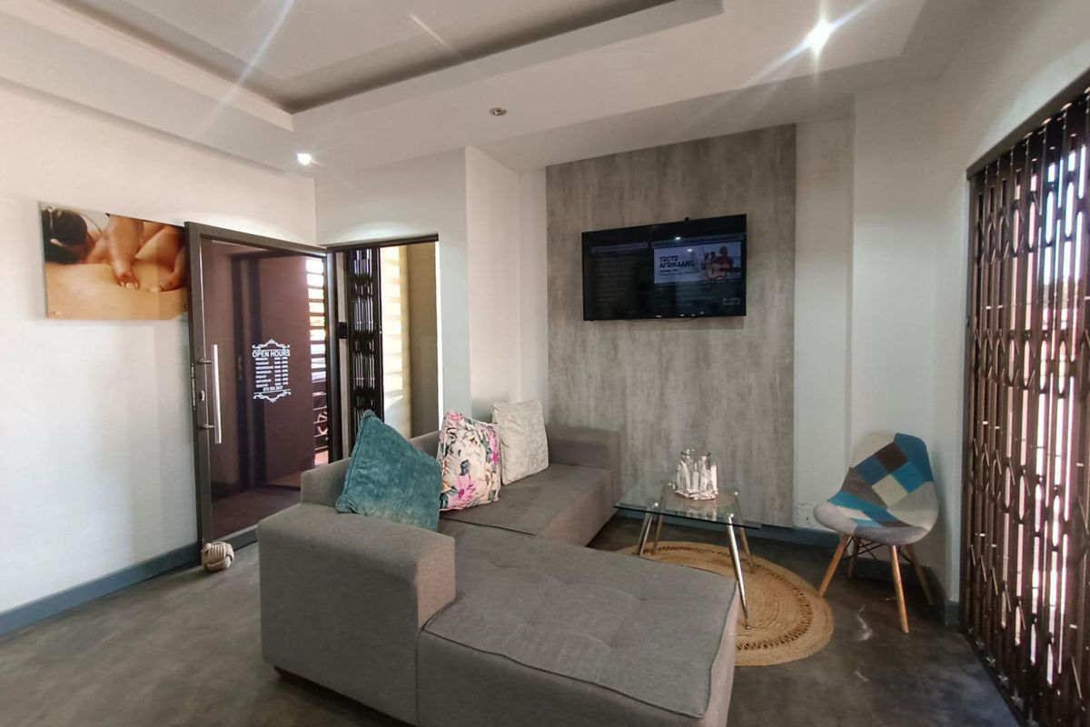 A modern reception or waiting area featuring polished concrete floors, a recessed ceiling with downlights, and a textured feature wall.