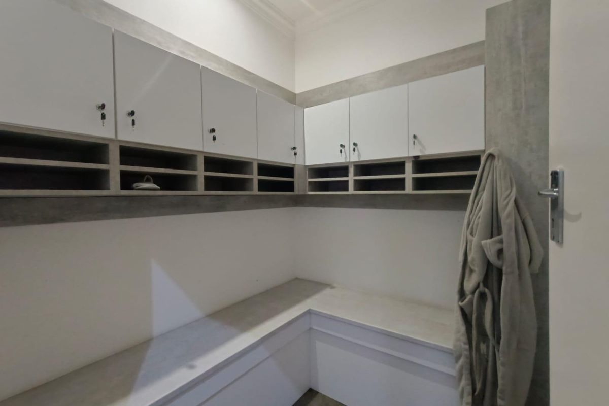 A functional utility space featuring built-in cabinetry, storage lockers, and integrated bench seating with a clean, modern finish.