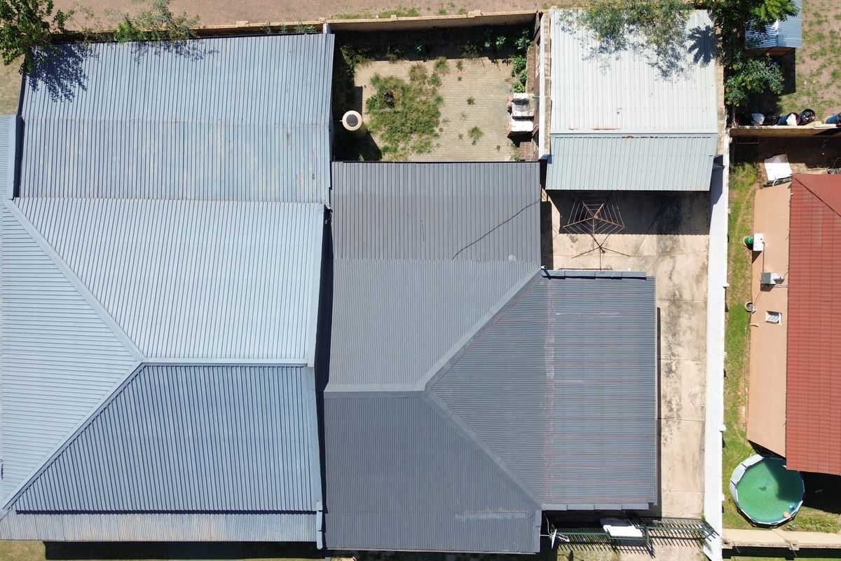Aerial view of the commercial property showing the roof structure, paved rear courtyard, and perimeter boundary walls.