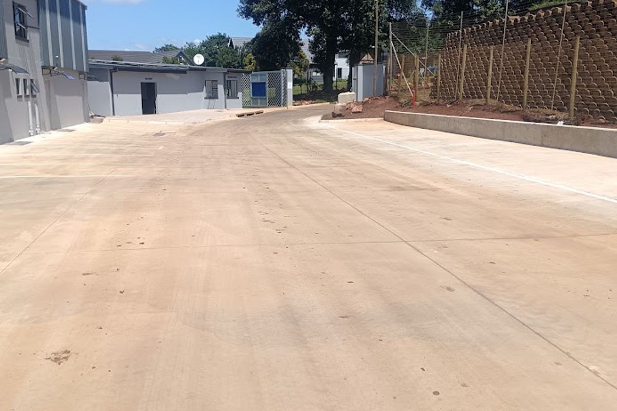 Spacious industrial concrete yard area with perimeter fencing and retaining wall, providing ample access and circulation space for commercial operations.