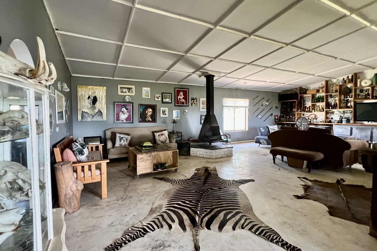 Spacious living area featuring a central freestanding fireplace, built-in shelving units, and a unique tiled ceiling design with concrete flooring.