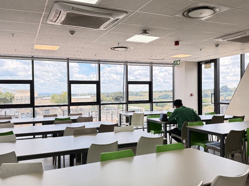 Spacious open-plan industrial office area featuring large windows with natural light, suspended ceilings, and integrated climate control systems.