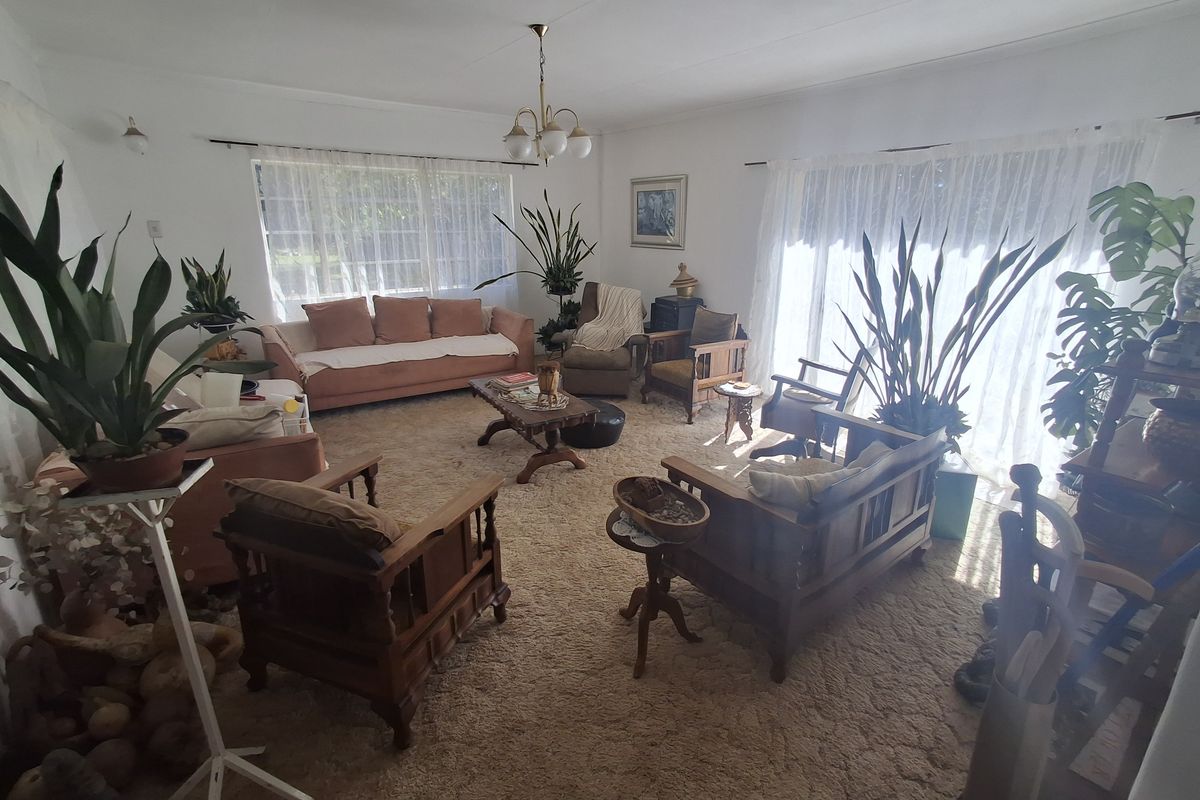 Spacious living room featuring wall-to-wall carpeting and large windows with natural light, offering a blank canvas for modern updates.